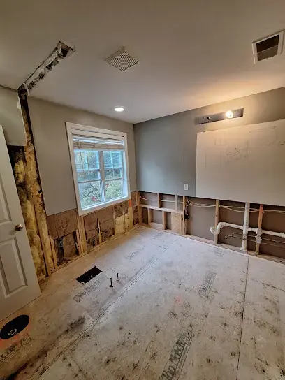 Wareham bedroom with drywall removed along the floor and bare subfloor exposed