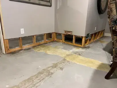 Flood-cut walls above bare concrete in an emptied Wareham basement