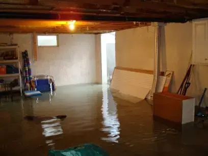Basement flooded with standing water around shelving and stored belongings